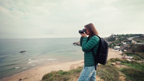 一名女摄影师在旅行时用相机拍摄海景的慢镜头 — 图库视频影像