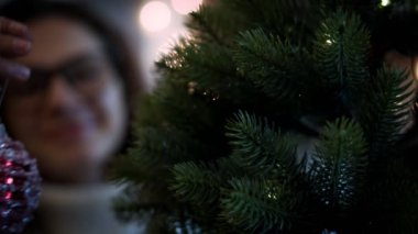 Beyaz bir kadının Noel ağacı süslediği yakın plan bir fotoğraf..
