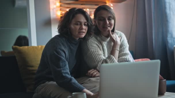 Young Lesbian Couple Doing Online Shopping Using Laptop Smartphone Winter — Stock Video