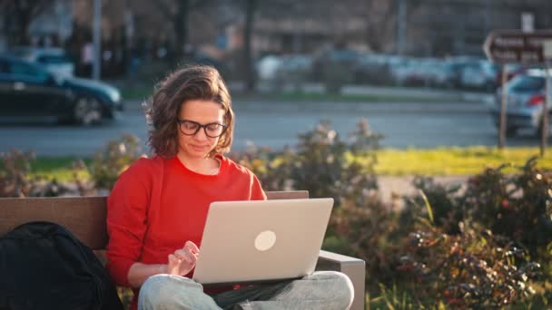 Young Caucasian Woman Wearing Glasses Typing Laptop While Sitting Bench — Stok video