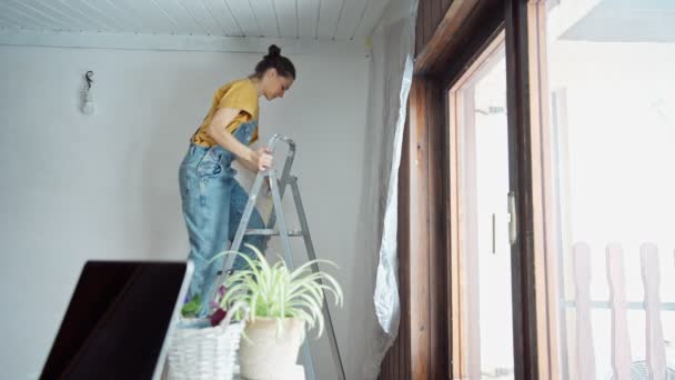 Young Caucasian Woman Preparing Room Painting Female Fixing Film Masking — 비디오