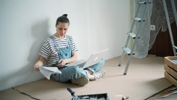 Young Caucasian Woman Typing Laptop While Sitting Floor Renovation Process — Vídeo de stock
