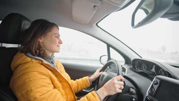 Ręczne Ujęcie Młodej Białej Kobiety Jasnożółtej Kurtce Prowadzącej Samochód — Wideo stockowe