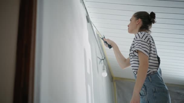 Μια Νεαρή Λευκή Γυναίκα Ζωγραφίζει Τον Τοίχο Έναν Κύλινδρο — Αρχείο Βίντεο