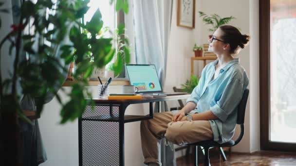 年轻的高加索人快乐的女人坐在笔记本电脑前的计算机椅子上放松地伸展着身体 — 图库视频影像