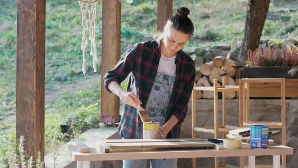 Young Caucasian Woman Using Brush Varnish Wooden Board While Standing — Stockvideo