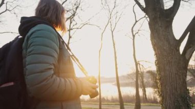 Yavaş çekimde profesyonel bir fotoğrafçının gün batımında manzara çekerken çekilmiş..
