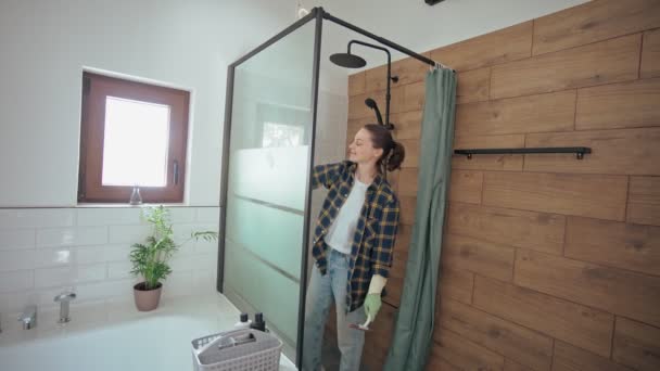 Eine Junge Kaukasische Frau Gummihandschuhen Reinigt Ein Duschglas Mit Schwamm — Stockvideo