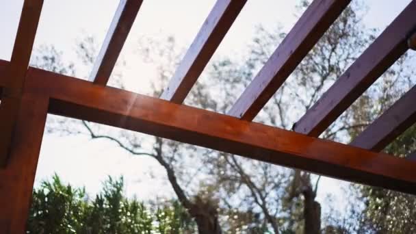 Abstract Cinematic Footage Bright Sun Shines Foliage Wooden Roof Pergola — Stock Video