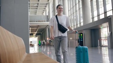 Bavullu genç bir bayan yolcu havaalanında uçağını bekliyor. 