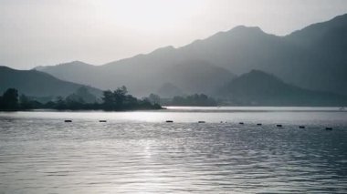 Huzurlu bir manzara. Gün doğumunda sakin denizi dağların arka planında görmek.