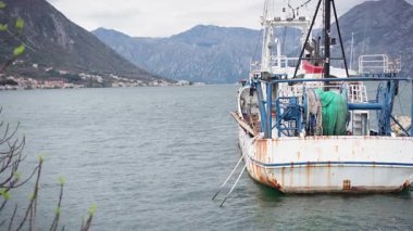 Bulutlu bir günde körfezin arka planında büyük eski bir balıkçı teknesi.