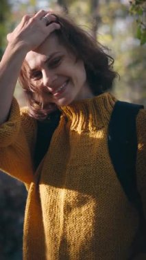 Sonbahar ormanında parlak sarı kazaklı güzel bir genç kadının portresi.