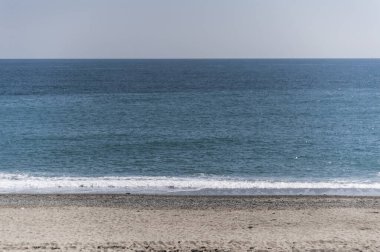 Sonbahar kışı. Güneşli bir günde az sayıda insanın olduğu terk edilmiş bir sahil..