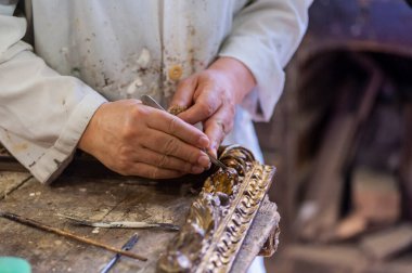 Zanaatkârlık, zanaatkarlık. Antika yaldızlı çerçevenin restorasyonu, tebeşirin yayıldığı fırçayı tutan el..