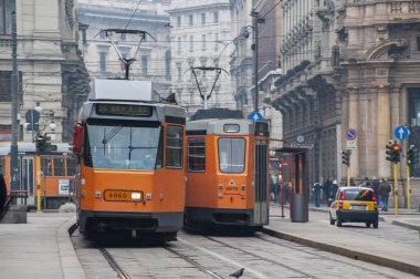 Milan, İtalya. Tramvaylar, şehirde toplu taşıma. Araç trafiği ve hareket halindeki insanlar