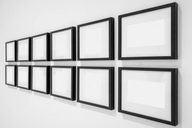 Beyaz duvarlı galeride, içi boş çerçeveler sergileniyor. Çerçevelerin beyaz iç kısmı resim veya metin eklenmesine olanak tanır. Çerçevelerin perspektifi.