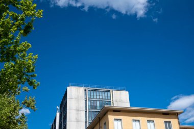 Mimarlık. Mavi gökyüzü ve beyaz bulutlu modern binaların alçak açılı görüntüsü..