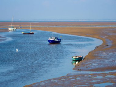 Dalgalar alçaldığında limandaki küçük tekneler Meols plajı Wirral UK.