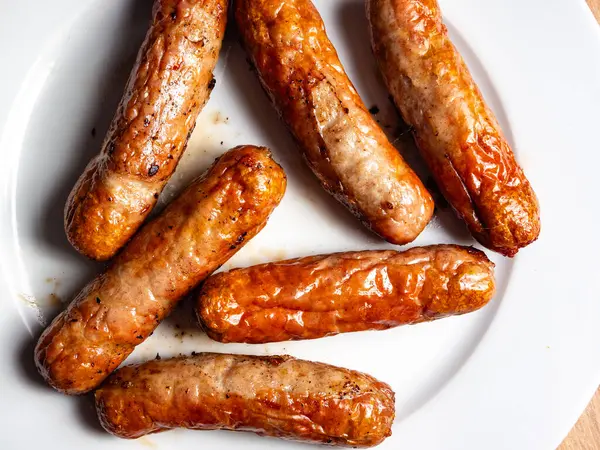 stock image Pork Sausage on a white plate a number of cooked meaty sausage