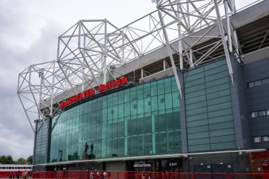 Manchester Trafford UK 29 Haziran 2024. Karmaşık metal iskeleti ve büyük cam girişi olan stadyumun dışı..