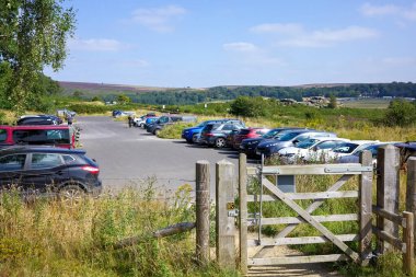 Hathersage moor, Derbyshire, UK, August, 31, 2024: Open car parking lot in a rural area with numerous parked vehicles surprise view car park. clipart