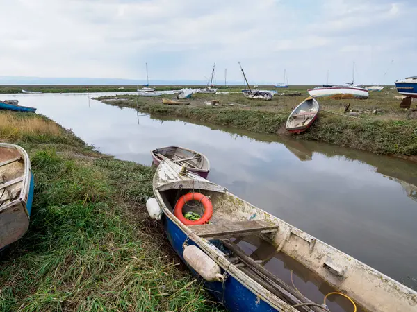 stock image Heswall, Dee estuary. Row of boats are sitting in a muddy river. The water is murky and the boats are old and worn