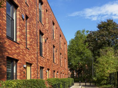 Salford, Manchester, İngiltere. 28 Eylül 2024: Güneşli bir günde huzurlu bir mahallede modern tuğla konak.