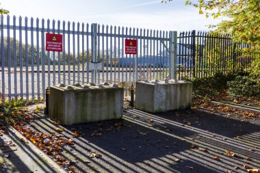 Sunlit industrial gate blocked with concrete blocks. clipart