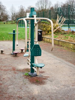 Bulutlu bir günde sessiz bir parkta açık hava egzersiz ekipmanları. Victoria park Swinton.