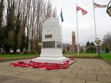 Swinton, Manchester, İngiltere, 31-12-2024: Beyaz savaş anıtı Swinton, Manchester bir park ortamında çelenkler ve bayraklarla çevrili.