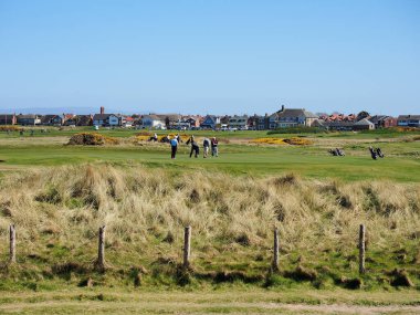 Fleetwood, Lancashire, İngiltere, 04-05-2025: Golfçüler banliyö bölgesi yakınlarındaki geniş ve açık bir golf sahasında güneşli bir günün tadını çıkarıyorlar.
