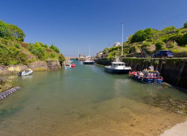 Amlwch, Anglesey, İngiltere, 05-17-2025: Bir grup tekne Amlwch Anglesey rıhtımına yanaştı. Farklı boyutlarda birkaç tekne var, büyük bir tekne ve küçük bir tekne de dahil. Liman bir kayma yolunun yanında.