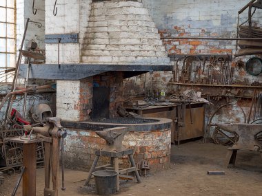 tuğla ocağı ve antika aletleri olan büyük bir kırsal demirci atölyesi..