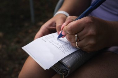 Bir kadın not defterine hassas bilgiler yazar.