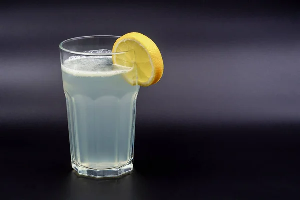 Koyu arkaplanda bardakta limonata.
