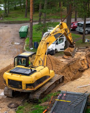 Sarı kazıcılı bir inşaat alanı.