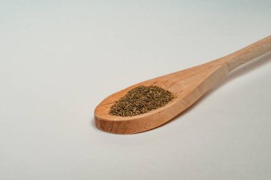 Beyaz arka planda izole edilmiş ahşap kepçe içindeki kuru kenevir yaprakları. Üst görünüm, kapat, boşluğu kopyala