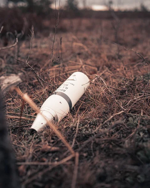 Yerde Duran Beyaz Plastik Bir Şişenin Dikey Yakın Çekimi — Stok fotoğraf