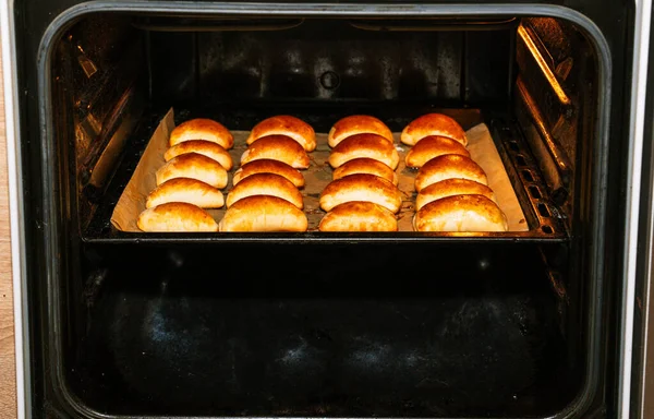 baking oven with baked bread rolls.