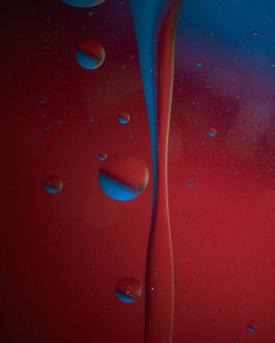 Su renk sıçrıyor. Su damlaları ve kırmızıyla soyut bir arkaplan. makro.