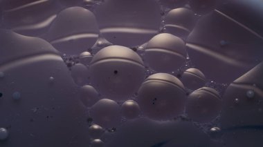 Mavi bir sıvının yüzeyine yağ damlaları düşer. Bir damla petrolle soyut arkaplan.