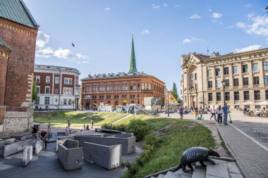 Riga, Letonya - 7 Temmuz 2023: Kafeler ve restoranlarla dolu Kubbe Meydanı, eski kasabadaki insanlar.