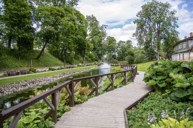 Kuldiga, Letonya - 3 Temmuz 2023: Göllü Kuldiga şehir bahçesi parkı, çeşmeler.