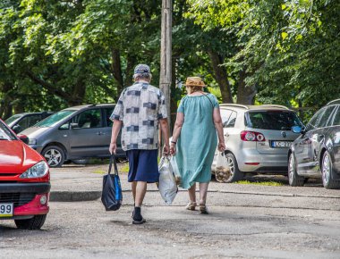 Liepaja, Letonya - 7 Temmuz 2023: Sebze taşıyan yaşlı çift.