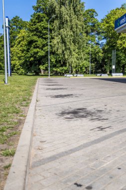 Liepaja, Letonya - 7 Temmuz 2023: araba yağının yol parkındaki lekeler. Asfaltta siyah yağ lekeleri var..