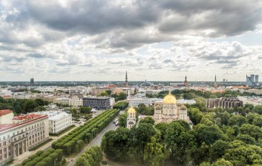 Riga, Letonya - 7 Temmuz 2023: Milda Anıtı Riga ve uzaktaki Ulusal Kütüphane 'nin gece vakti Letonya Oteli' nden bir manzara.