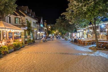 Zakopane, Poland- 16 Temmuz 2023: gece vakti Zakopane 'de ünlü Krupowki caddesi. Krupowki caddesi, merkezdeki ana alışveriş alanı ve yaya geçidi..