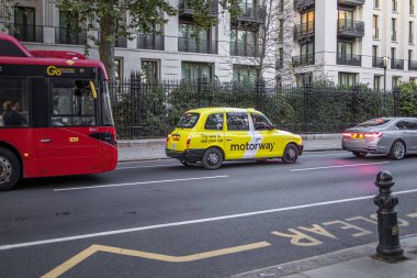 London, UK - September 14, 2023: London Yellow Cab Taxi with Motorway car sales auction Ad Advertisement clipart