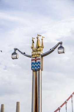 London, UK - September 14, 2023: One of the four art deco style lamp A golden galleon ship posts at the entrances to Chelsea Bridge. clipart